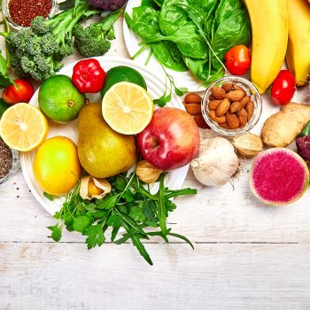 Natural products rich in antioxidants and vitamins on white wooden background. Virus protection food, coronavirus, immunity concept. Healthy clean and detox food. Top view, flat lay, copy space.